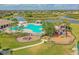 Aerial view of a large community pool with playground, cabana and landscaping, next to a pond at 12304 Silton Peace Dr, Riverview, FL 33579