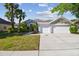 Charming single-story home featuring a three car garage, large driveway, and lush landscaping at 12304 Silton Peace Dr, Riverview, FL 33579