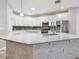 Modern kitchen island with marble countertops, stainless steel appliances, and sleek white cabinets at 12304 Silton Peace Dr, Riverview, FL 33579