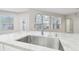 Close-up of a kitchen sink, marble countertops, and abundant natural light from nearby windows at 12304 Silton Peace Dr, Riverview, FL 33579