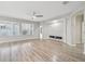 Bright living room featuring wood-look floors, a contemporary fireplace, and large windows for natural light at 12304 Silton Peace Dr, Riverview, FL 33579