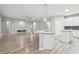 Open-concept kitchen and living area with wood-look floors, a fireplace accent wall, and modern lighting at 12304 Silton Peace Dr, Riverview, FL 33579