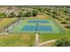 Aerial view of community tennis courts with blue and green surfacing surrounded by secure fencing at 12304 Silton Peace Dr, Riverview, FL 33579