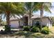 Inviting single-story home with lush landscaping and a two-car garage, creating a welcoming curb appeal at 14205 Stockwell Ln, Ruskin, FL 33573