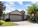 Well-maintained single-Gathering home showcasing a two-car garage, and manicured lawn at 14205 Stockwell Ln, Ruskin, FL 33573