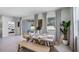 Dining room with large windows, neutral walls, and a rustic wooden table with wicker chairs at 19664 Gladeview Way, Land O Lakes, FL 34638