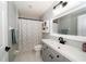 Updated bathroom featuring a gray vanity, modern fixtures, and stylish shower curtain at 2206 Green Oaks Ln, Tampa, FL 33612