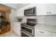 Well-appointed kitchen boasts stainless steel appliances, white cabinetry and subway tile backsplash at 2206 Green Oaks Ln, Tampa, FL 33612