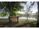 Relaxing view of a bench overlooking the peaceful lake, shaded by trees, offering a serene spot for reflection at 2206 Green Oaks Ln, Tampa, FL 33612