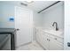 The laundry room offers modern cabinets, a utility sink, and modern fixtures at 2206 Green Oaks Ln, Tampa, FL 33612