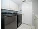Modern laundry room with sleek appliances, ample storage cabinets, and marble-style tile flooring at 2206 Green Oaks Ln, Tampa, FL 33612