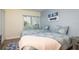 Cozy bedroom featuring two twin beds with beach-themed decor and natural light from the window at 2211 Belleair Rd # D12, Clearwater, FL 33764