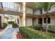 A well-maintained apartment building exterior with landscaped walkway and courtyard view on a sunny day at 2211 Belleair Rd # D12, Clearwater, FL 33764