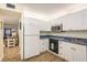 Bright kitchen featuring white cabinetry, wood-look flooring, and modern appliances for easy meal prep at 2211 Belleair Rd # D12, Clearwater, FL 33764