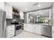 Bright kitchen with stainless steel appliances, granite countertops and breakfast bar opening to living area at 2414 Hounds Trl, Palm Harbor, FL 34683