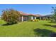 Well-maintained backyard with lush green grass, blooming tree, screened-in porch, and well-kept landscaping at 29488 Ginnetto Dr, Wesley Chapel, FL 33543