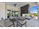 Inviting outdoor fireplace lounge area features comfortable seating, sleek stone accents, and lush landscaping at 29488 Ginnetto Dr, Wesley Chapel, FL 33543