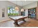 A billiard room provides hours of entertainment, featuring a pool table with views of the outdoor landscaping at 29488 Ginnetto Dr, Wesley Chapel, FL 33543