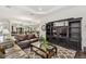 Open living area with a large TV, built-in shelving, and a view into the dining room at 29488 Ginnetto Dr, Wesley Chapel, FL 33543