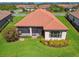 Aerial view of a home featuring a red tile roof, screened-in lanai, and manicured landscaping at 29488 Ginnetto Dr, Wesley Chapel, FL 33543