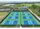 Aerial view of tennis and pickleball courts in a Florida community with landscaping and palm trees at 29488 Ginnetto Dr, Wesley Chapel, FL 33543