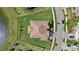 Aerial view of a home with a tile roof, beautiful lawn, and waterfront views at 33105 Kateland Dr, Wesley Chapel, FL 33545