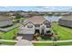 Beautiful home with three-car garage, tiled roof, and landscaping, situated near a serene lake at 33105 Kateland Dr, Wesley Chapel, FL 33545