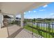 Relaxing covered balcony overlooking water view, with a hanging chair and wrought iron railing at 33105 Kateland Dr, Wesley Chapel, FL 33545