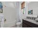 Updated bathroom with white tiled walls, a granite countertop, and decorative patterned shower curtains at 33105 Kateland Dr, Wesley Chapel, FL 33545