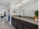 Modern bathroom featuring a granite countertop, dark wood cabinetry, and tiled flooring at 33105 Kateland Dr, Wesley Chapel, FL 33545