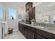 Bright bathroom featuring granite counters, dual sinks, and a seamless glass shower at 33105 Kateland Dr, Wesley Chapel, FL 33545