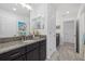 Bathroom with granite countertop, dark wood cabinets, and marble floors at 33105 Kateland Dr, Wesley Chapel, FL 33545