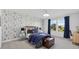 This bedroom features a fun wallpaper, a window that provides lots of natural light and a desk area at 33105 Kateland Dr, Wesley Chapel, FL 33545