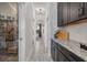 Hallway with tiled floors, leading to a pantry and other rooms, offering seamless flow and accessibility at 33105 Kateland Dr, Wesley Chapel, FL 33545