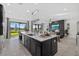 Modern kitchen island overlooking the living room and outdoor lake view through sliding glass doors at 33105 Kateland Dr, Wesley Chapel, FL 33545