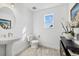 Chic powder room featuring a pedestal sink, modern lighting, and neutral decor at 33105 Kateland Dr, Wesley Chapel, FL 33545
