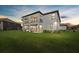 Home's rear elevation showing a covered patio, second-floor balcony, and a spacious lawn at 33105 Kateland Dr, Wesley Chapel, FL 33545