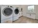 Bright laundry room with modern washer and dryer and custom cabinetry with marble countertops at 3418 Overlook Ne Dr, St Petersburg, FL 33703