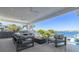 Covered outdoor living space with water views, a fire pit, and comfortable seating, perfect for relaxation at 3418 Overlook Ne Dr, St Petersburg, FL 33703