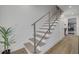 Bright stairway with natural wood steps, cable railing and wood flooring leading to other rooms at 3418 Overlook Ne Dr, St Petersburg, FL 33703