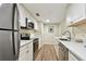 Modern kitchen featuring stainless steel appliances, white cabinetry, and stylish wood-look flooring at 36750 Us 19 N # 06211, Palm Harbor, FL 34684
