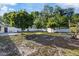 A spacious backyard featuring a well-maintained lawn, mature trees, and a white privacy fence for added seclusion at 4105 W Iowa Ave, Tampa, FL 33616