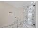 Spacious bathroom with marble tile flooring, glass-enclosed shower with marble tile, and modern fixtures at 4105 W Iowa Ave, Tampa, FL 33616
