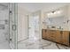 Modern bathroom with dual sink vanity, glass enclosed shower with marble tile, and marble tile flooring at 4105 W Iowa Ave, Tampa, FL 33616