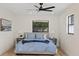 Bright bedroom featuring a ceiling fan, two windows, and a comfortable bed with grey nightstands at 4105 W Iowa Ave, Tampa, FL 33616