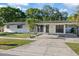 Well-lit single-story home with a covered carport, concrete driveway, and manicured front yard at 4105 W Iowa Ave, Tampa, FL 33616