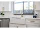 Modern kitchen sink featuring white cabinetry, quartz countertop, and stainless steel dishwasher at 4105 W Iowa Ave, Tampa, FL 33616