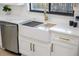 Bright kitchen sink featuring stainless steel appliances, white cabinetry, and gold fixtures at 4105 W Iowa Ave, Tampa, FL 33616