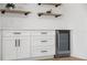 Elegant wet bar features white cabinetry, floating shelves, and beverage cooler at 4105 W Iowa Ave, Tampa, FL 33616