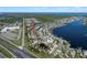 An aerial view captures a neighborhood with a pond and road near a glistening blue lake, perfect for peaceful living at 513 Manns Harbor Dr, Apollo Beach, FL 33572